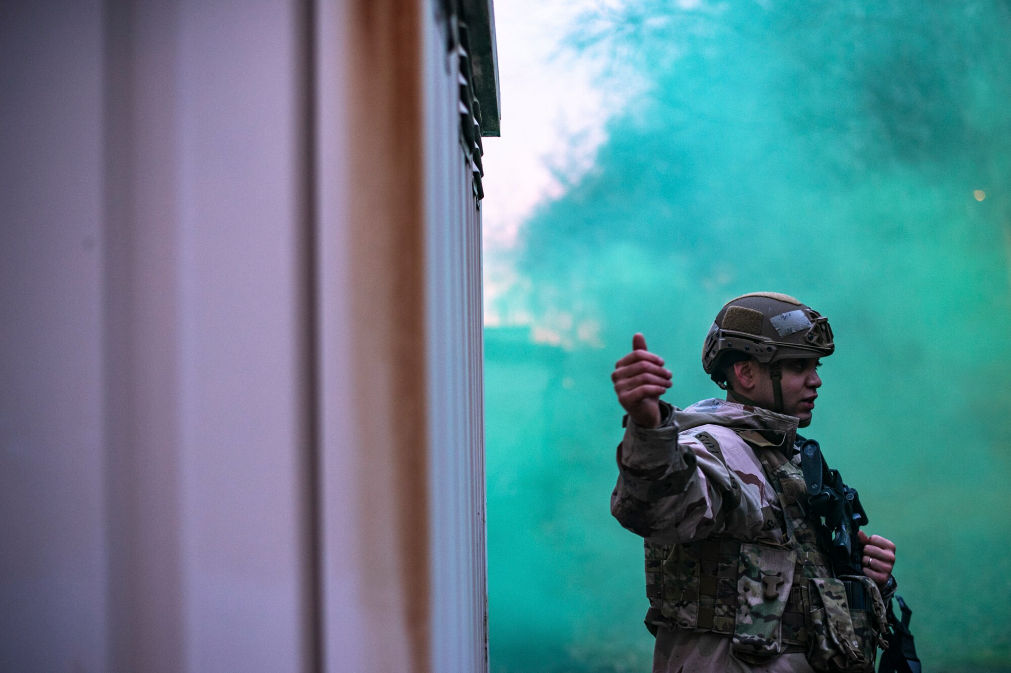 U.S. Air Force Staff Sgt. Deylin Cortellini, 569th U.S. Forces Police Squadron member, signals his comrades during a simulated ground attack as part of exercise Operation Varsity 19-04 at Kapaun Air Station, Germany, Dec. 11, 2019. The use of hand signals provides defenders a discreet way of communicating when dealing with hostile scenarios. (U.S. Air Force photo by Staff Sgt. Devin Boyer)