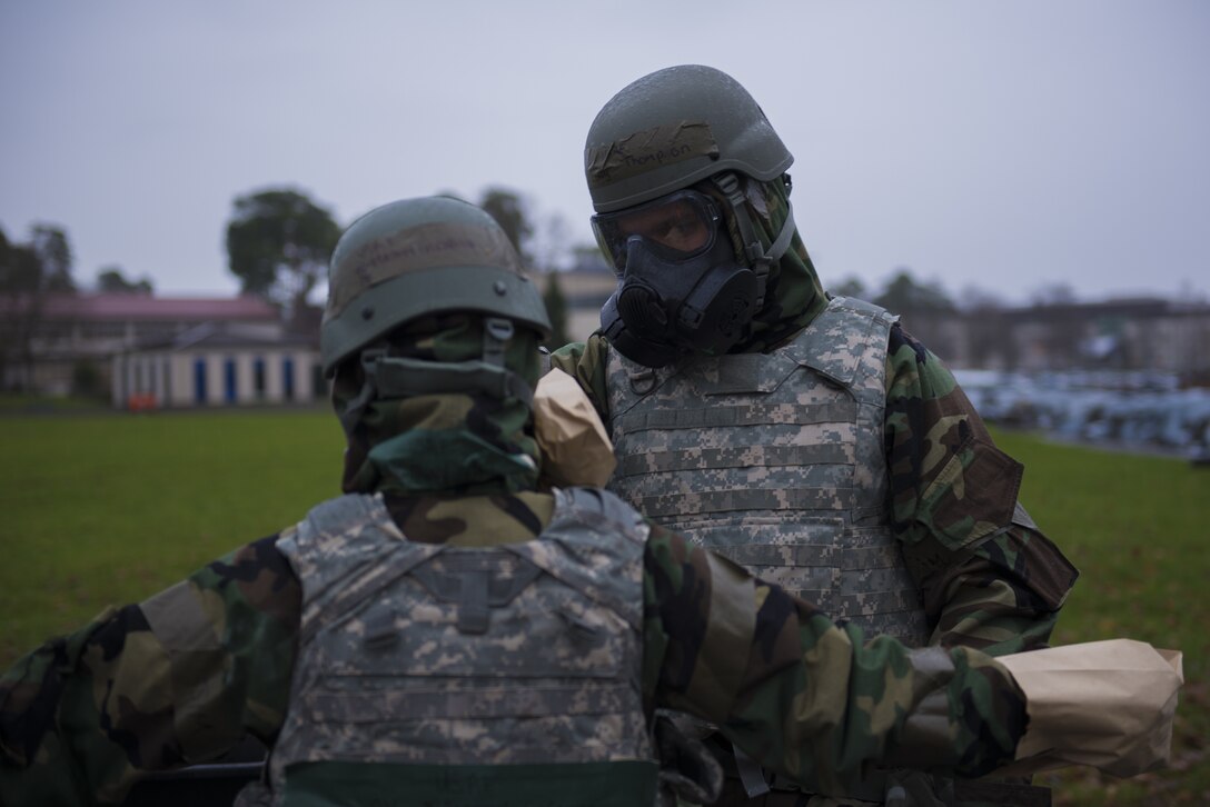U.S. Air Force Airman First Class Mallory Glennon, left, and Staff Sgt. Lanny Thompson, 86th Dental Squadron dental assistants, decontaminate each other using a simulated M295 mitt, at Ramstein Air Base, Germany, Dec. 11, 2019.The pair practiced how to remove contamination in the event of a chemical attack as part of exercise Operation Varsity 19-04. (U.S. Air Force Photo by Senior Airman Kaylea Berry)