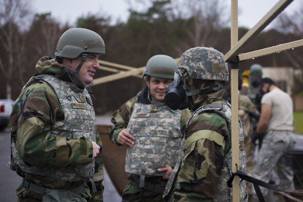 U.S. Air Force Brig. Gen. Mark R. August, 86th Airlift Wing commander, left, and Chief Master Sgt. Ernesto J. Rendon, 86th AW command chief, speak to Airman 1st Class Sean Hurley, 786th Civil Engineer Squadron emergency management training journeyman, about the importance of preparedness and emergency response at Ramstein Air Base, Germany, Dec 11, 2019. The 86th AW participated in Operation Varsity 19-04 to promote readiness among Airmen. (U.S. Air Force Photo by Senior Airman Kaylea Berry)