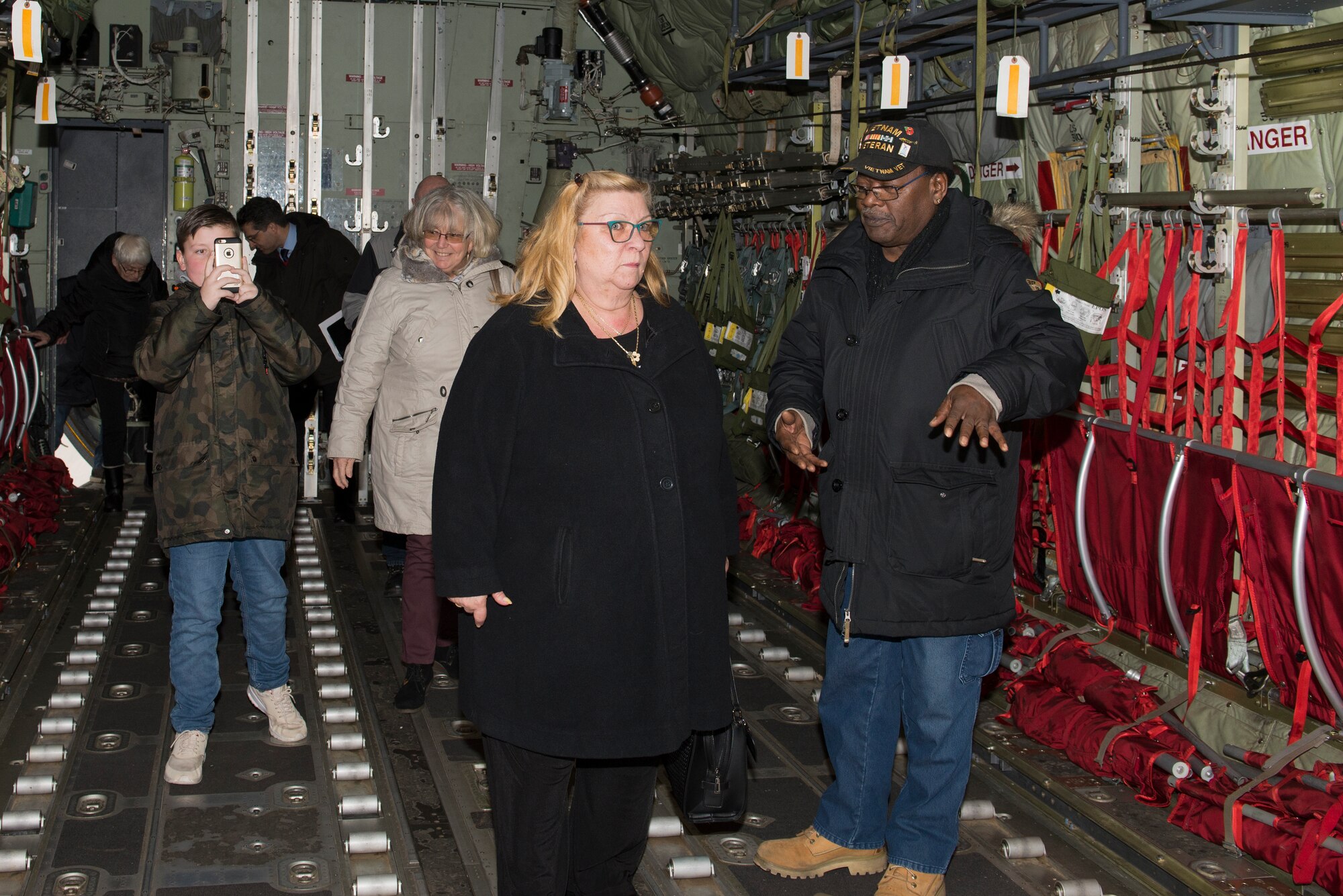 Calvin Churchill, right, discusses the intricacies of the C-130J Hercules aircraft with his wife Lourdes Soriano, left, at Ramstein Air Base, Germany, Dec. 6, 2019.  Earlier in the day, the couple attended a length-of-service ceremony where Soriano was recognized for 20 years of U.S. government service.
