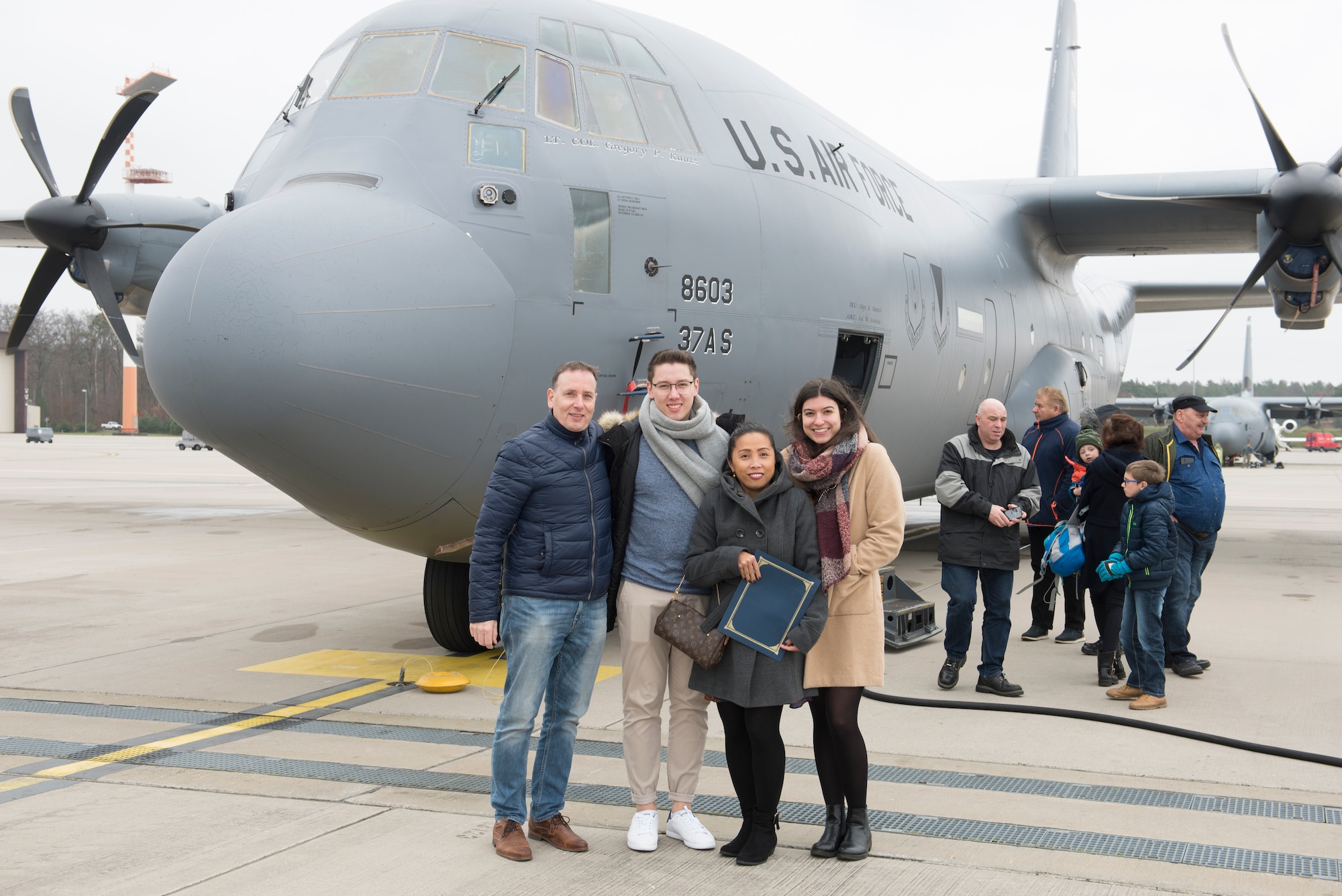 Amelita Bugard, center, a 25-year length-of-service honoree, poses for a photo with her family in front of a C-130J Hercules aircraft at Ramstein Air Base, Germany, Dec. 6, 2019. Earlier in the day, families attended a length-of-service ceremony recognizing more than 100 civil servants for long-standing employment with the U.S. government. After the ceremony, family and friends were invited on a base tour to learn more about Ramstein Air Base’s mission and capabilities.