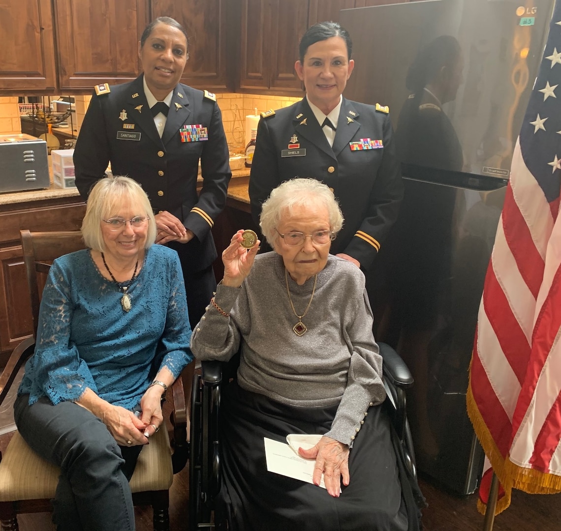 Freda Haworth Coate (front row, right) holds the Army Nurse Corps Association coin given to her by Lt. Col. Karen Santiago (back row, left) and Lt. Col. Teresa Shiels, both with the 228 Combat Support Hospital in San Antonio. The coin was given to Coate during her 100th birthday celebration Nov. 20 in Leander, Texas. Coate served in the U.S. Army Nurse Corps in World War II in the South Pacific from 1943-45.