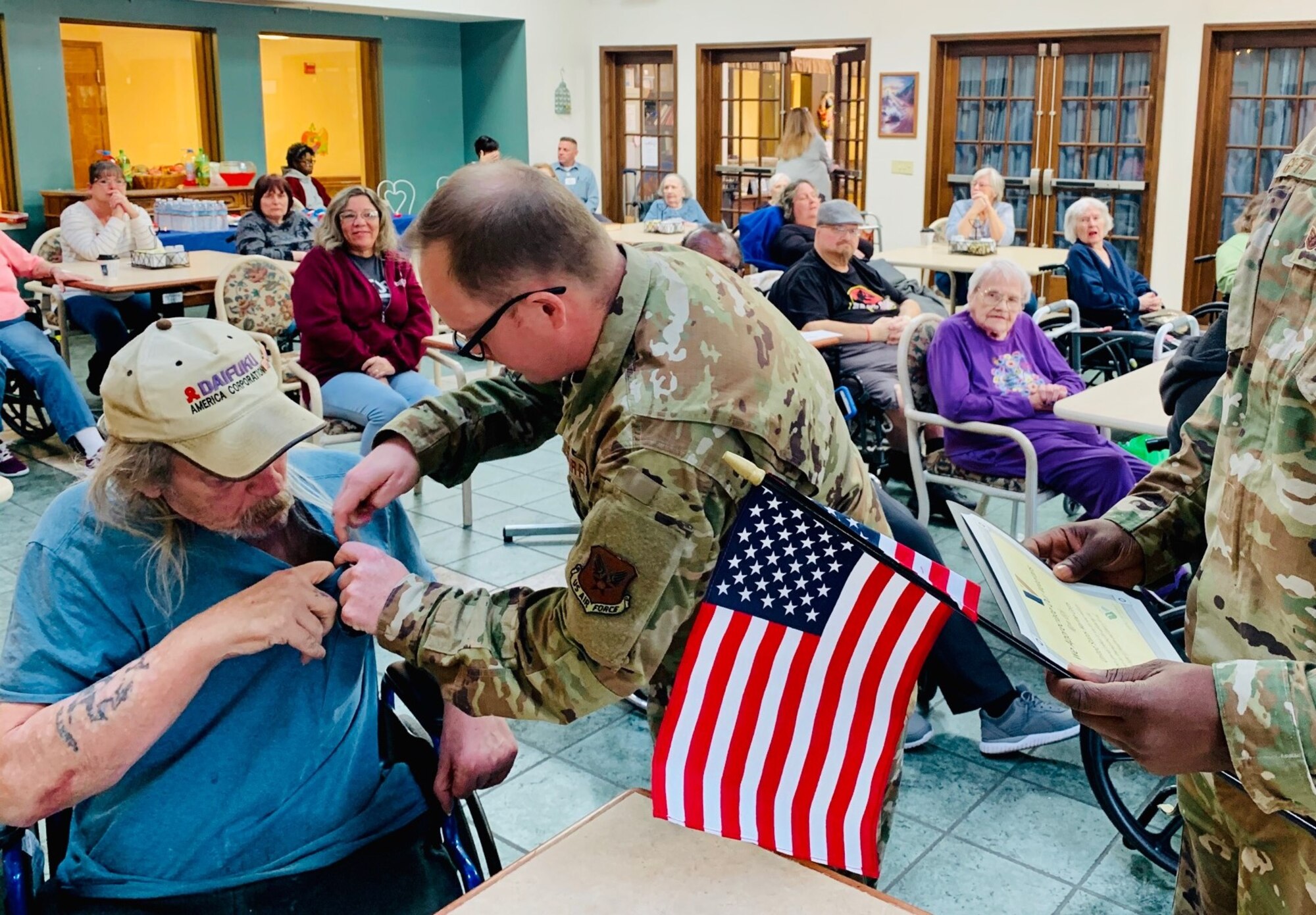 Members of the National Air and Space Intelligence Center volunteer at the Hospice of the Miami Valley on Veterans Day, Nov. 11, 2019. During the day, a team of nearly 15 service members read an oath of service, rendered a courtesy salute to the veterans and honored them for serving the United States.  The event concluded with a medal pinning, awarding of a certificate of appreciation and an American Flag presented to each veteran in hospice care. (U.S. Air Force courtesy photo)