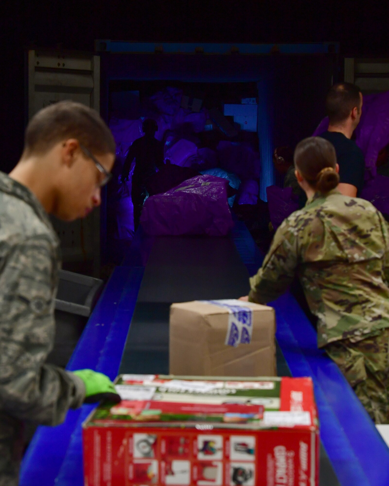 Military postal clerks and volunteers unload and sort parcels from a mail truck at the Northside Post Office, Ramstein Air Base, Germany, Dec. 6, 2019.