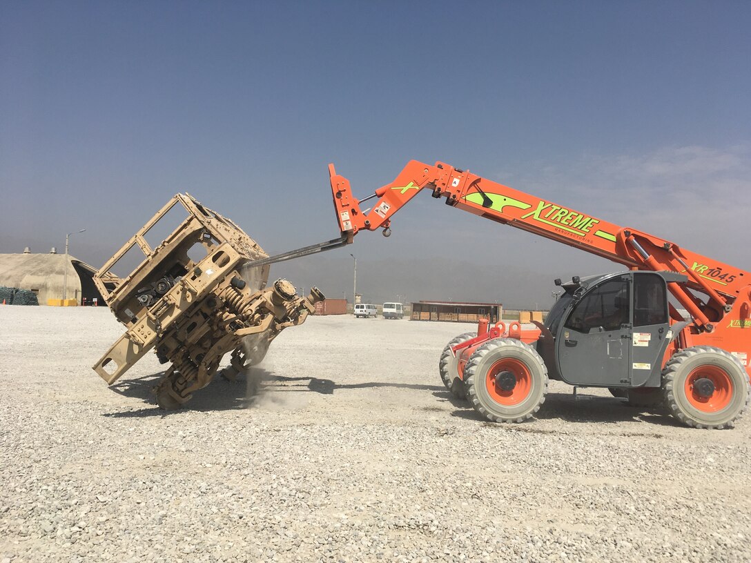 An equipment operator from the property management contractor performs the final steps of the ammo inspection process, a 90-degree roll-over of the vehicle.