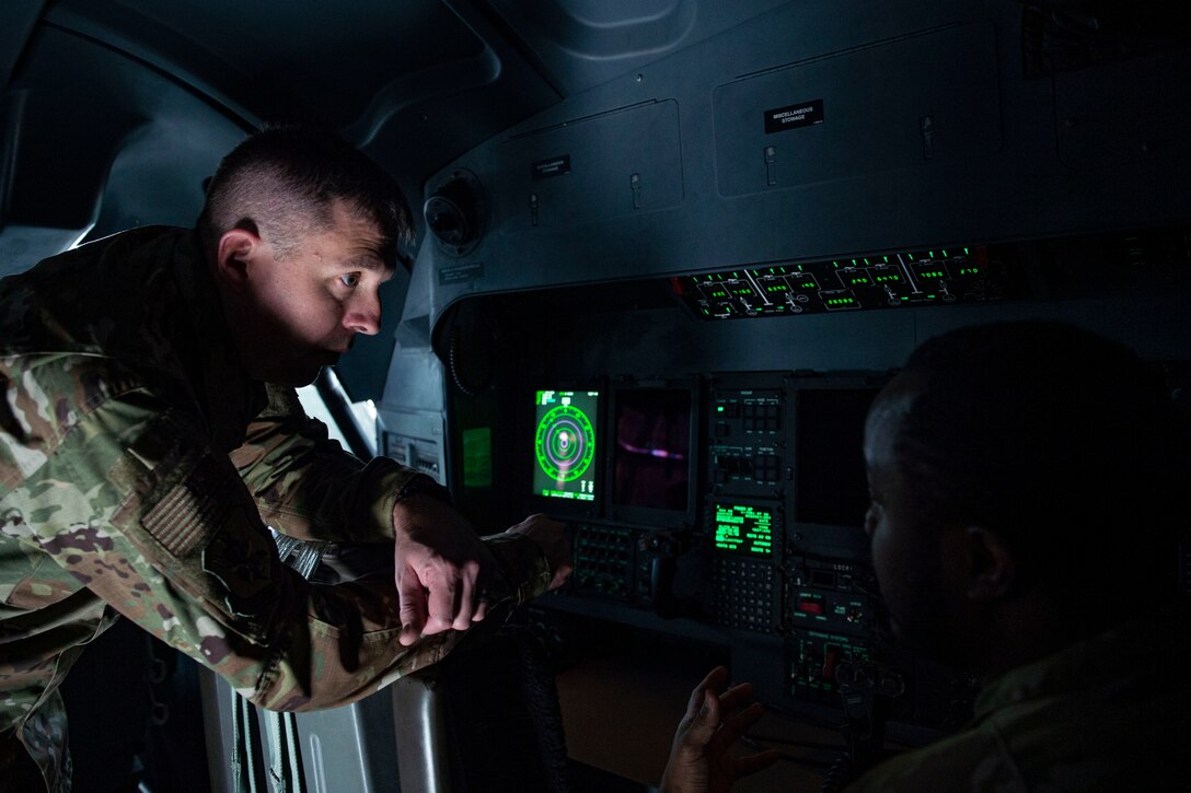 Photo of an Airman briefing another in a cockpit of an HC-130J Combat King during a 71st RQS tour