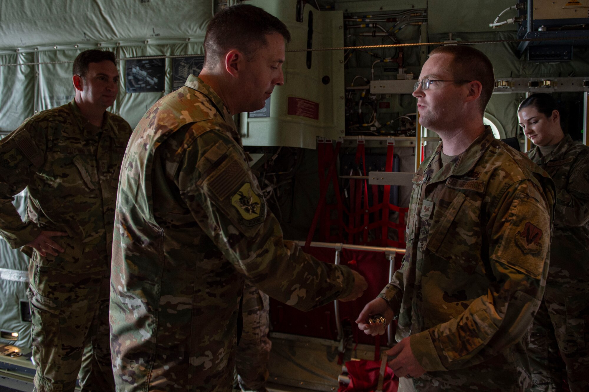 Photo of the wing commander coining an Airman
