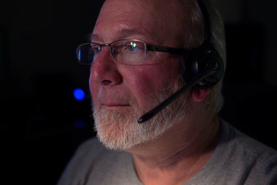 Photo of an Airman communicating with a range control officer through a headset.