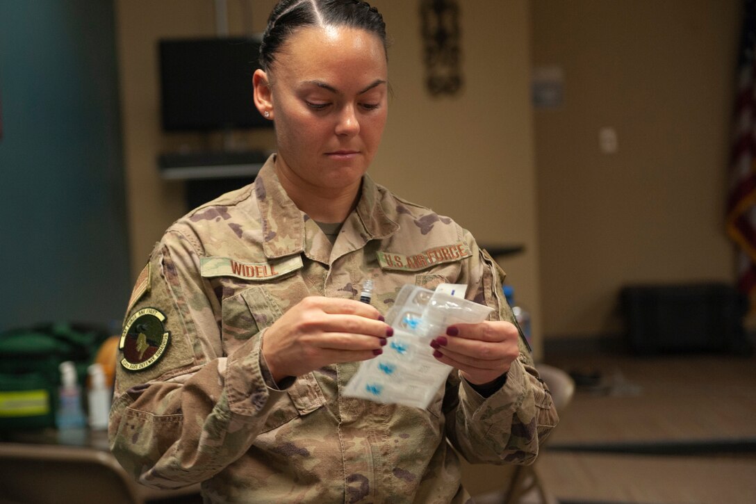A photo of an Airman unpackaging flu shots