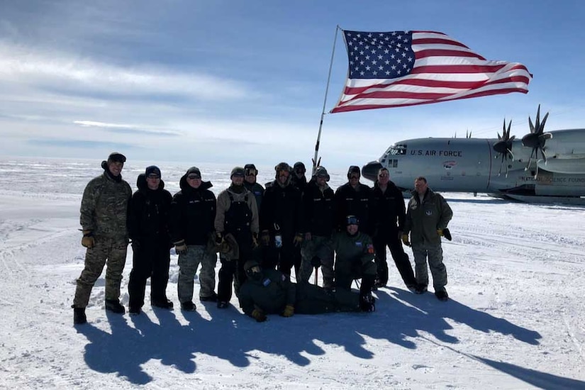 Airmen display an American flag in the Arctic.