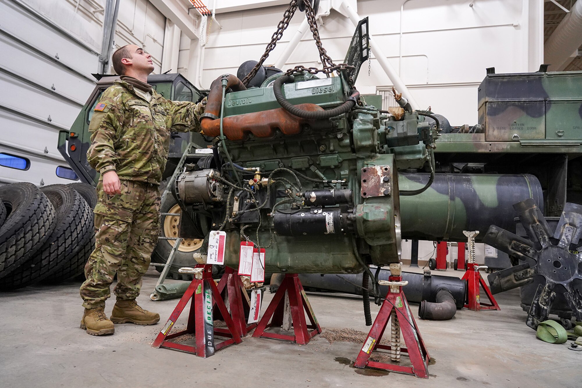 Army Sgt. Tyler Hale, a native of Wilmington, N.C., assigned to the 109th Transportation Company, 17th Combat Sustainment Support Battalion, U.S. Army Alaska, guides a damaged engine from an M984A2 Heavy Expanded Mobility Tactical Truck wrecker onto jack stands in his unit’s motor pool on Joint Base Elmendorf-Richardson, Alaska, Dec. 13, 2019. The M984A2 is an eight-wheel drive, diesel-powered, variant of the HEMTT used in vehicle recovery operations.
