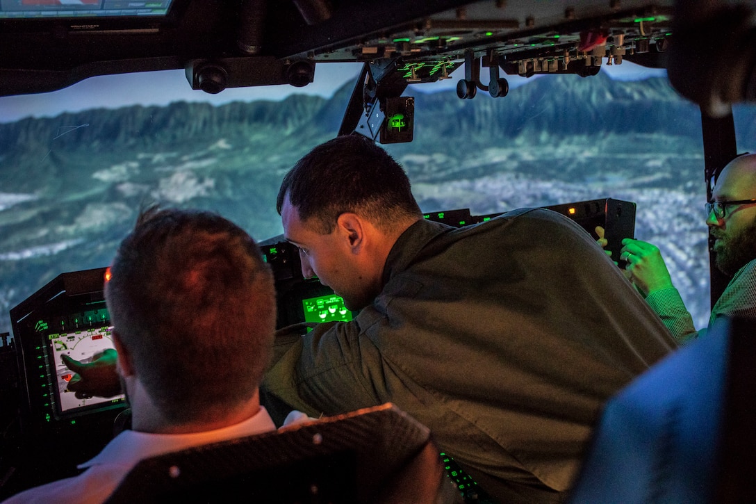 U.S. Marine Corps Capt. Nicholas Patinos, the future operations officer for Marine Medium Tiltrotor Squadron (VMM) 363, assists a New Zealand professor during an MV-22B Osprey flight simulation during New Zealand professor's tour of Marine Corps Base Hawaii (MCBH), Dec. 11, 2019. The professors toured MCBH to learn about the Hawaii Marine Air-Ground Task Force and the base's mission in the U.S. Indo-Pacific region. The tour included a static display of amphibious assault vehicles, MV-22B Ospreys with Marine Medium Tiltrotor Squadron 363, and a flight simulation of an Osprey. (U.S. Marine Corps photo by Cpl. Matthew Kirk)