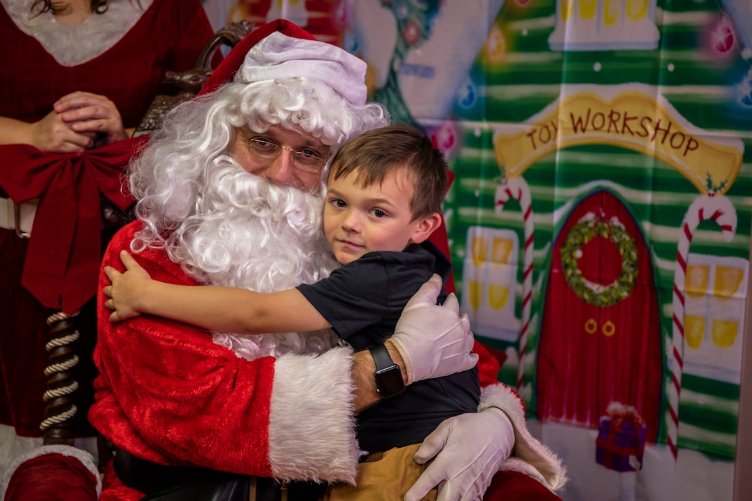 A child hugs Santa Claus during Operation Homefront, Marine Corps Base Hawaii (MCBH), Dec. 7, 2019. Operation Homefront helps provide MCBH families that are separated during the holiday season with meals and toys. The event also included arts and crafts and pictures with Santa Claus. (U.S. Marine Corps photo by Cpl. Matthew Kirk)