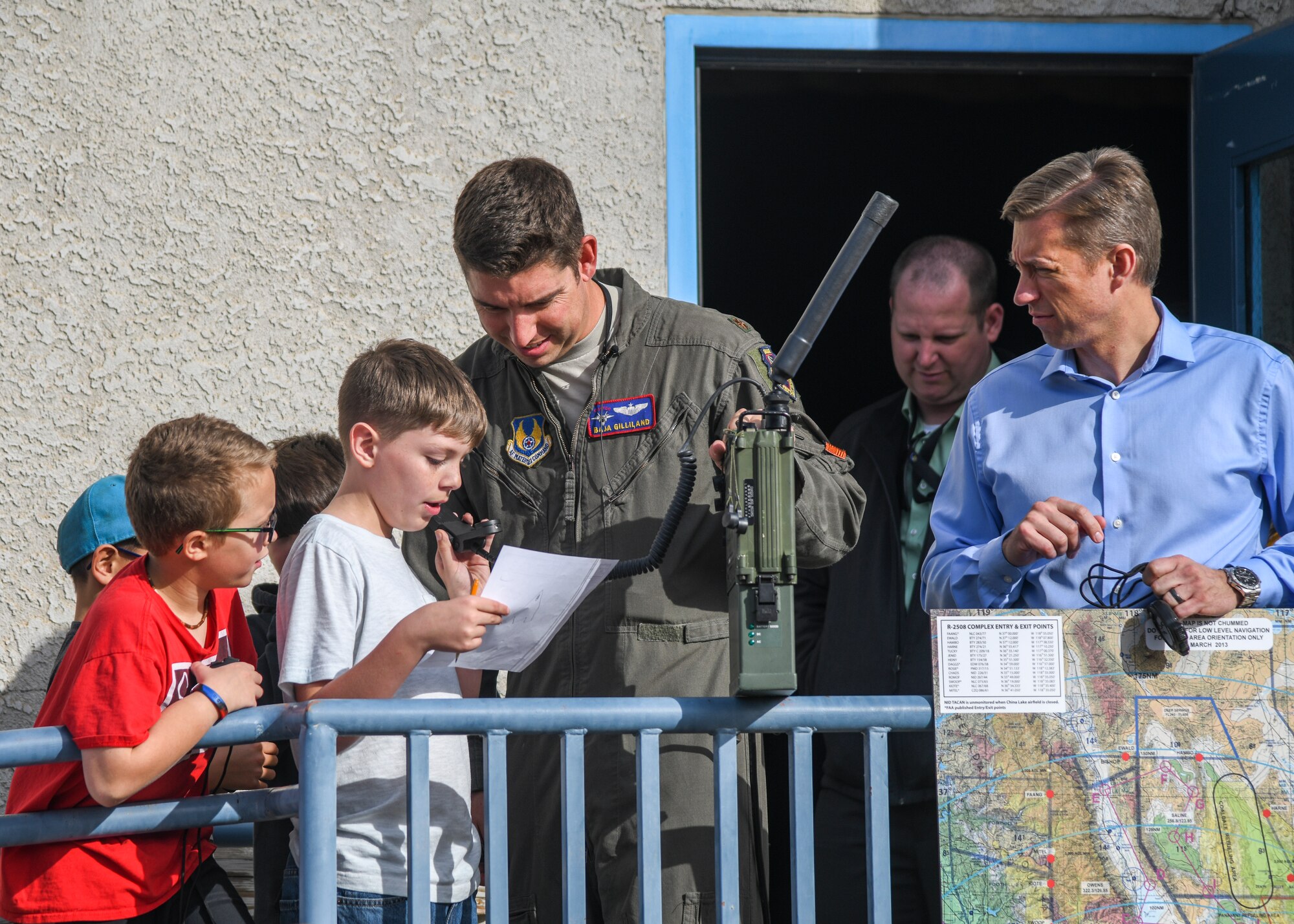 Maj. Ben Gilliland, Orange Flag Director, 411th Flight Test Squadron, assists a STARBASE Edwards student on providing coordinates to an airborne fighter pilot during an Orange Flag exercise at Edwards Air Force Base, California, Dec. 10. (Air Force photo by Giancarlo Casem)