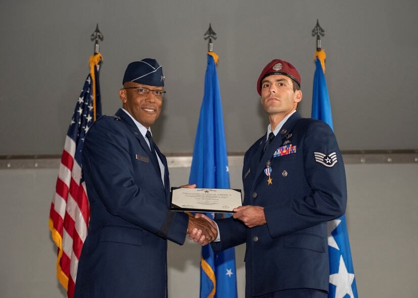 An Airman holds an award while presenting it to another Airman.