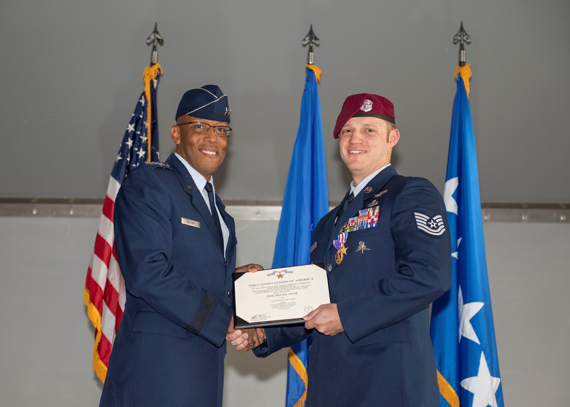 An Airman holds an award while presenting it to another Airman.