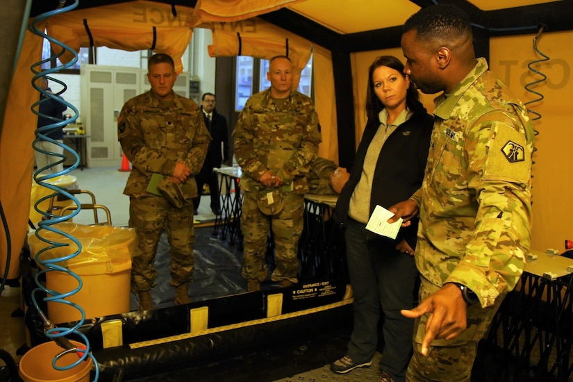 U.S. Army Reserve Staff Sgt. Antwon Williams, a human resources noncommissioned officer with the 773rd Civil Support Team, 7th Mission Support Command, explains decontamination capabilities to Dr. Brandi C. Vann, deputy assistant secretary of defense for U.S. Chemical and Biological Defense, while she tours the 773rd headquarters on Panzer Kaserne in Kaiserslautern, Germany, December 11, 2019. The 773rd is the only Civil Support Team in the U.S. Army Reserve and the European theater of operations. (U.S. Army Reserve photo by Sgt. 1st Class Joy Dulen)