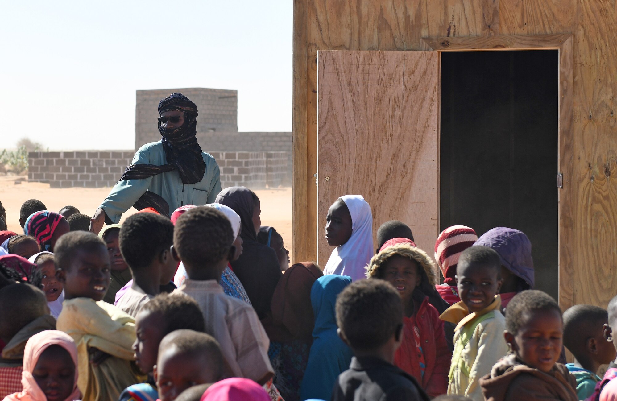 School children gather during a dedication ceremony of their new classroom in the village of Tadress, Niger, Dec. 12, 2019. Coordinated by members of the U.S. Army 443rd Civil Affairs Battalion CAT 219, Airmen deployed to the 724th Expeditionary Air Base Squadron Civil Engineer Flight, Nigerien Air Base 201, constructed the new classroom for the students. In Niger, a teacher is only assigned to a class if there is a building to teach in. (U.S. Air Force photo by Staff Sgt. Alex Fox Echols III)