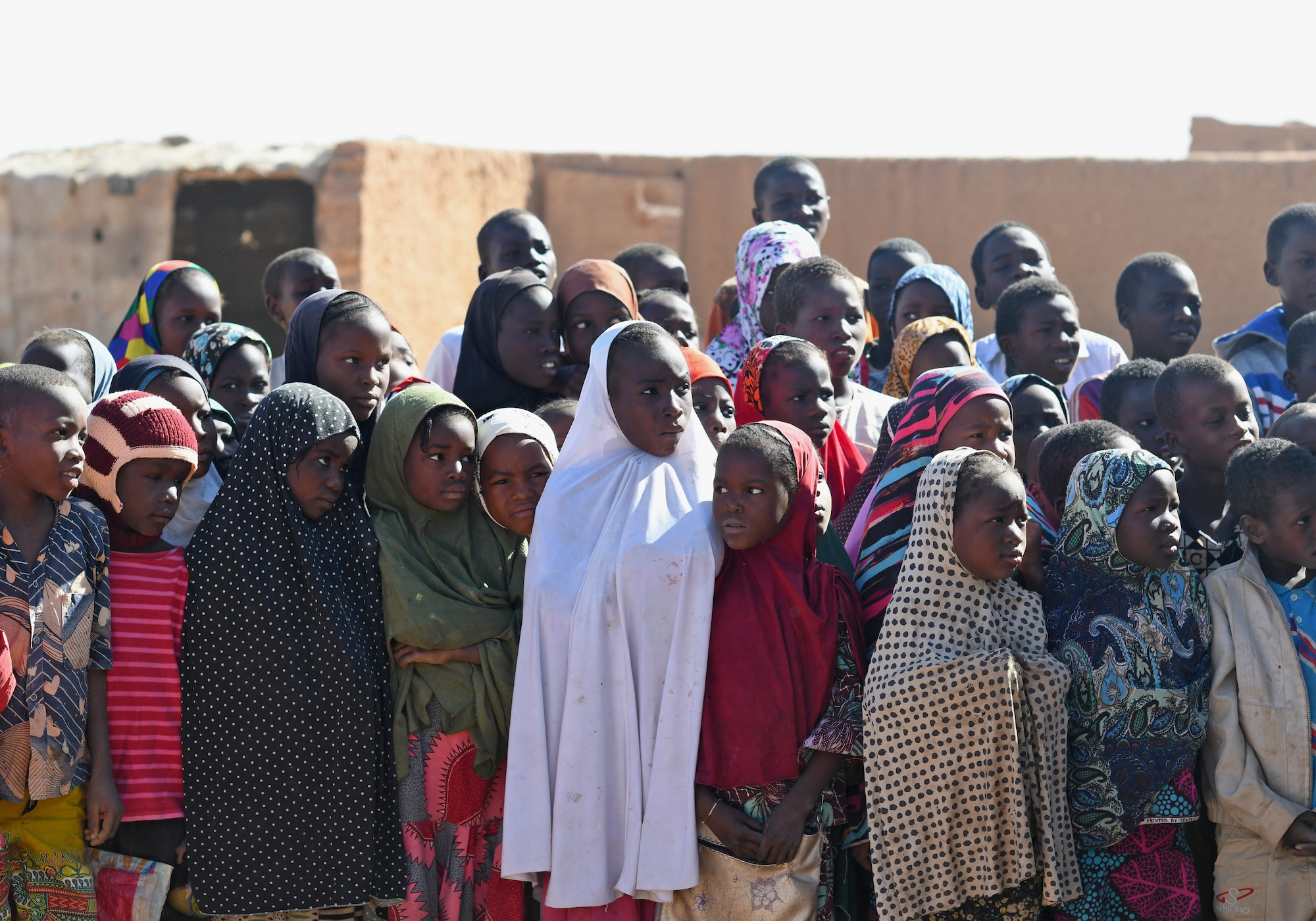 School children gather during a dedication ceremony of their new classroom in the village of Tadress, Niger, Dec. 12, 2019. Coordinated by members of the U.S. Army 443rd Civil Affairs Battalion CAT 219, Airmen deployed to the 724th Expeditionary Air Base Squadron Civil Engineer Flight, Nigerien Air Base 201, constructed the new classroom for the students. In Niger, a teacher is only assigned to a class if there is a building to teach in. (U.S. Air Force photo by Staff Sgt. Alex Fox Echols III)