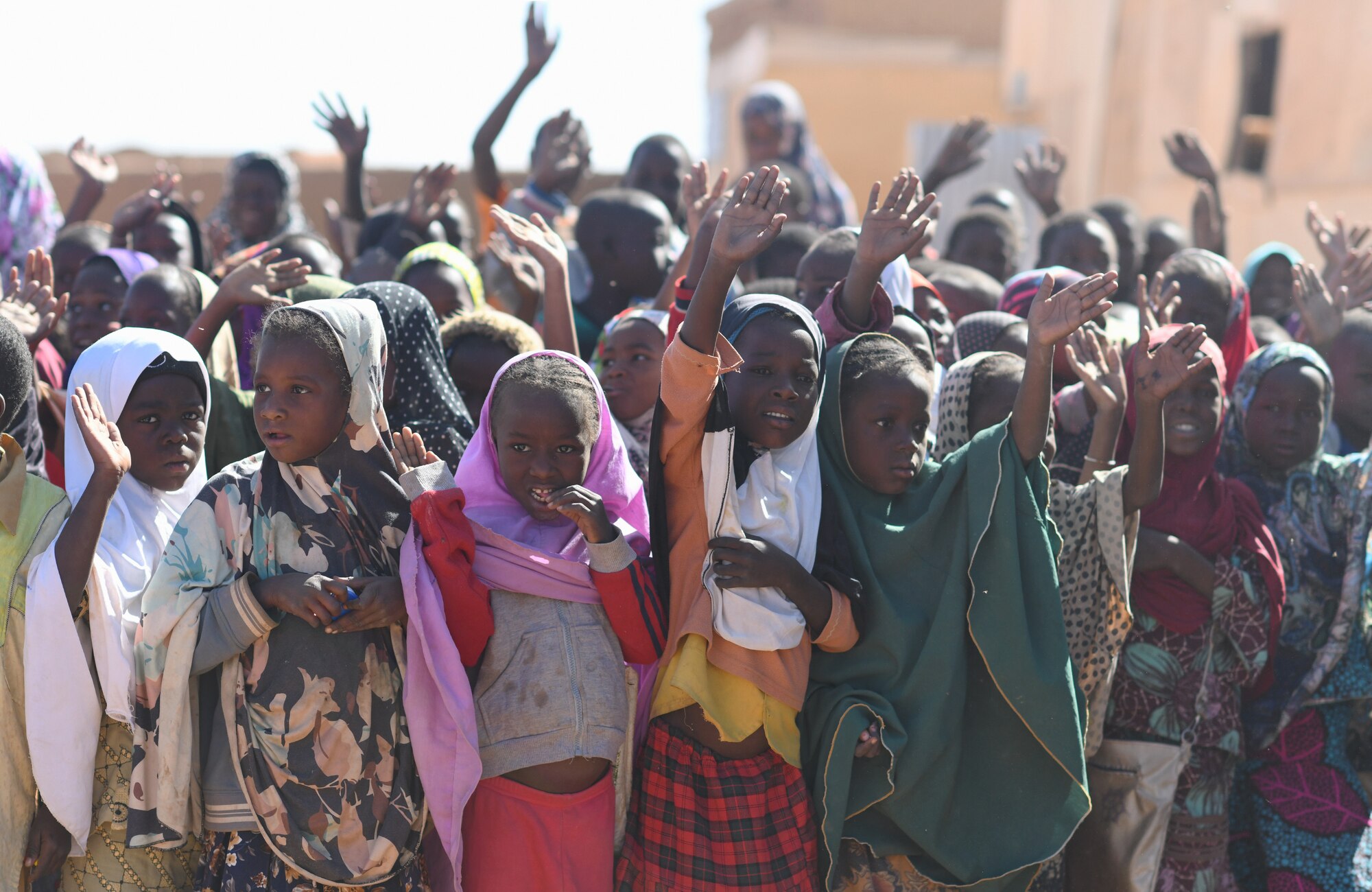 School children wave during a dedication ceremony of their new classroom in the village of Tadress, Niger, Dec. 12, 2019. Coordinated by members of the U.S. Army 443rd Civil Affairs Battalion CAT 219, Airmen deployed to the 724th Expeditionary Air Base Squadron Civil Engineer Flight, Nigerien Air Base 201, constructed the new classroom for the students. In Niger, a teacher is only assigned to a class if there is a building to teach in. (U.S. Air Force photo by Staff Sgt. Alex Fox Echols III)