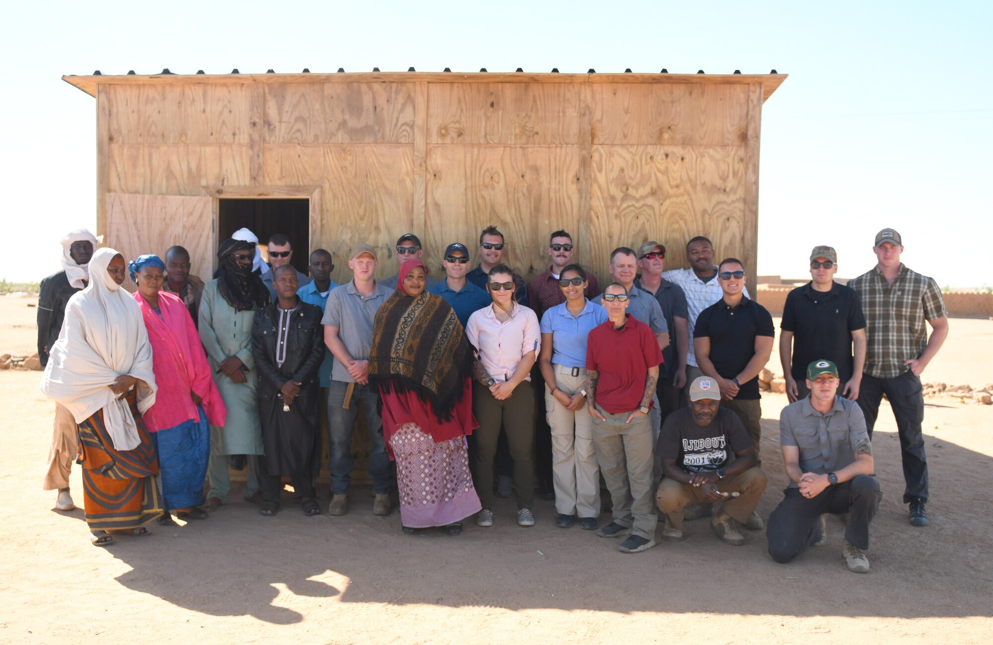 Local teachers, village elders and U.S. military members deployed to Nigerien Air Base 201 pose for a photo outside a newly built classroom in the village of Tadress, Niger, Dec. 12, 2019. Coordinated by members of the U.S. Army 443rd Civil Affairs Battalion CAT 219, Airmen deployed to the 724th Expeditionary Air Base Squadron Civil Engineer Flight constructed the new classroom for the students. In Niger, a teacher is only assigned to a class if there is a building to teach in. (U.S. Air Force photo by Staff Sgt. Alex Fox Echols III)