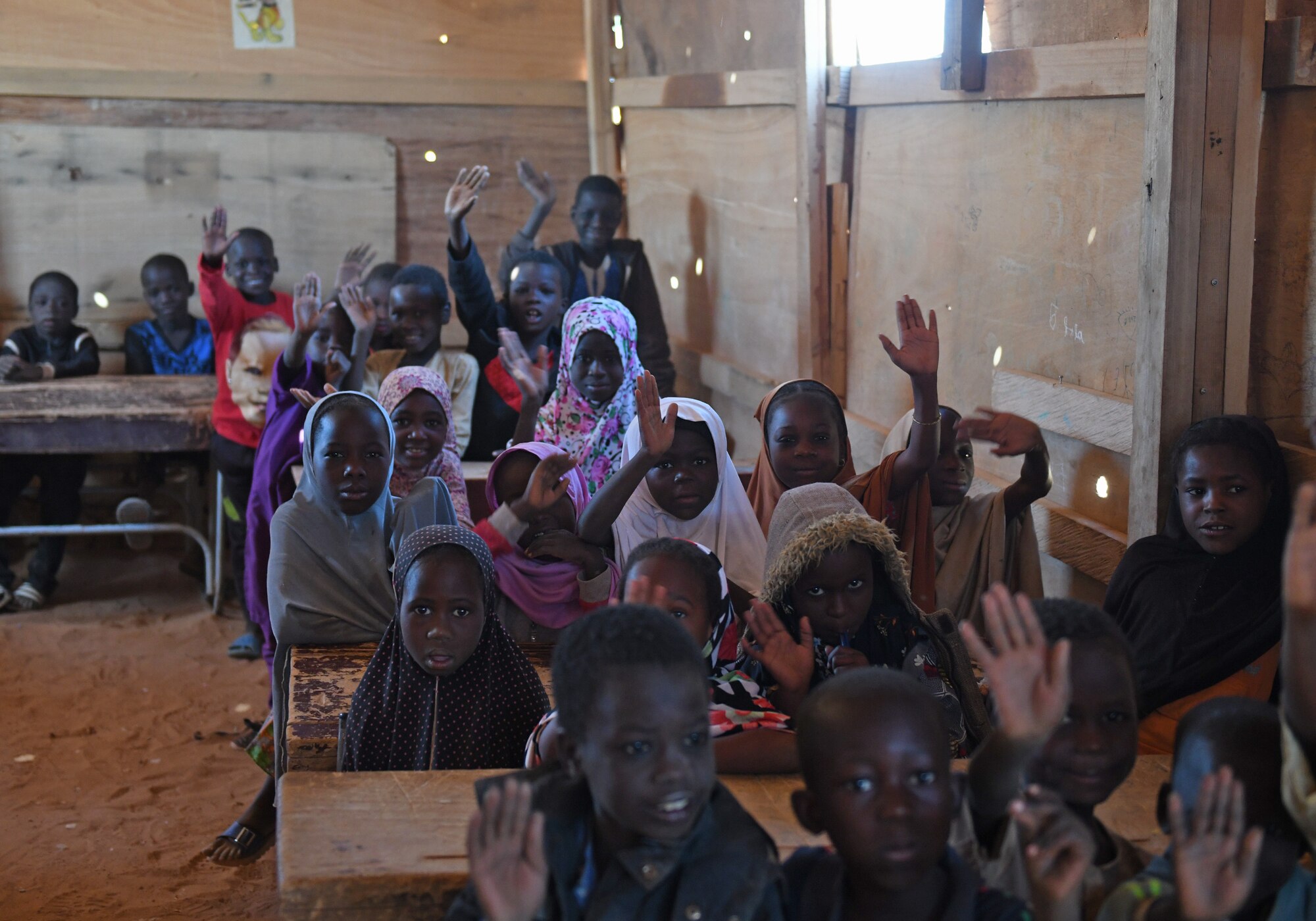 School children sit inside an older classroom in the village of Tadress, Niger, Dec. 12, 2019. Coordinated by members of the U.S. Army 443rd Civil Affairs Battalion CAT 219, Airmen deployed to the 724th Expeditionary Air Base Squadron Civil Engineer Flight, Nigerien Air Base 201, constructed a new classroom for the students. In Niger, a teacher is only assigned to a class if there is a building to teach in. (U.S. Air Force photo by Staff Sgt. Alex Fox Echols III)