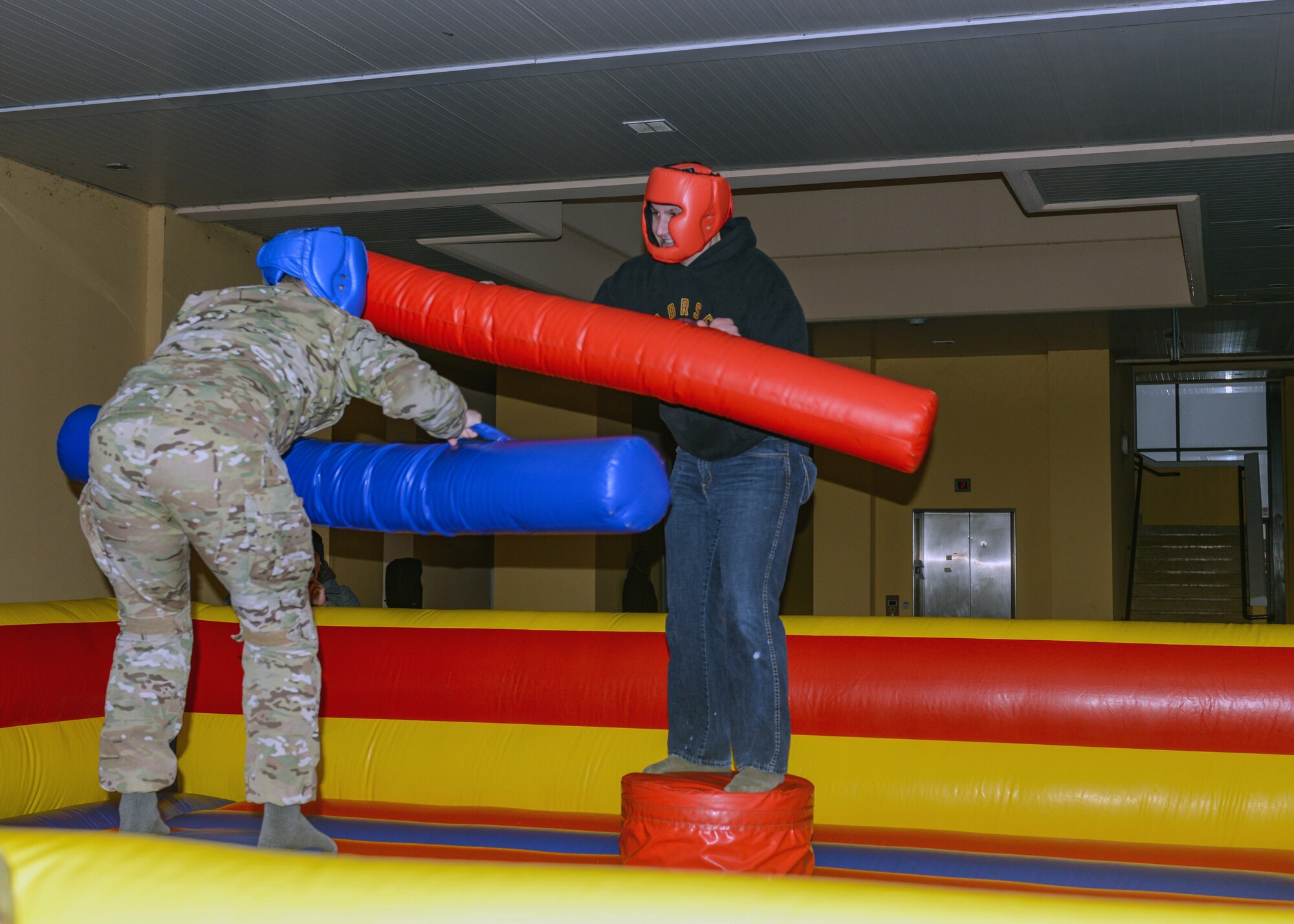 U.S. Air Force Airmen from the 31st Fighter Wing compete with pugil sticks during a grand opening ceremony at Aviano Air Base, Italy, Dec. 13, 2019. The Airmen Against Drunk Driving team supplied the pugil sticks for the dorm Airmen. (U.S. Air Force photo by Airman Thomas S. Keisler IV)