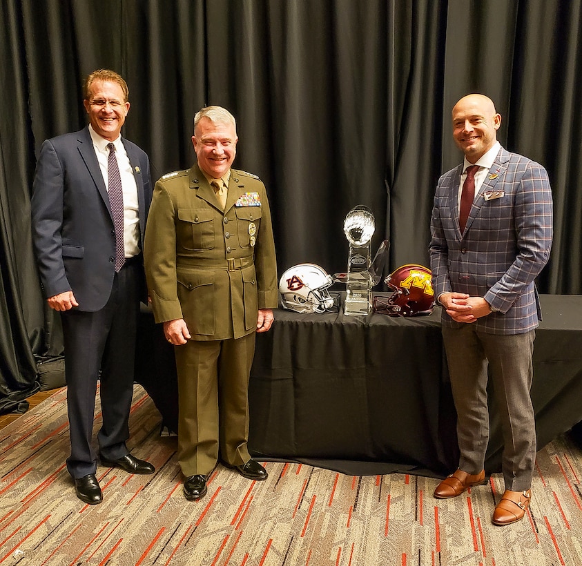 U.S. Marine Corps Gen. Kenneth F. McKenzie Jr., center, the commander of U.S. Central Command, Gus Malzahn, left, the head coach of the Auburn Tigers football team, and Philip John Fleck Jr., the head coach of the Minnesota Golden Gophers, pose for a photo at Raymond James Stadium in Tampa, Florida, Dec. 12, 2019. (U.S. Army photo by CPT Jennifer Cruz)