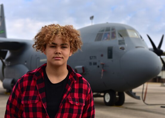 A student walks on a flight line and sits in a large aircraft