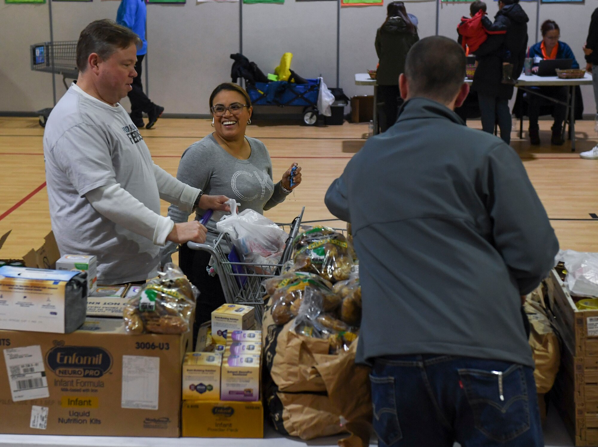 An event volunteer pushes a participant’s grocery cart during a holiday food distribution at Joint Base Langley-Eustis, Virginia, Dec. 11, 2019.