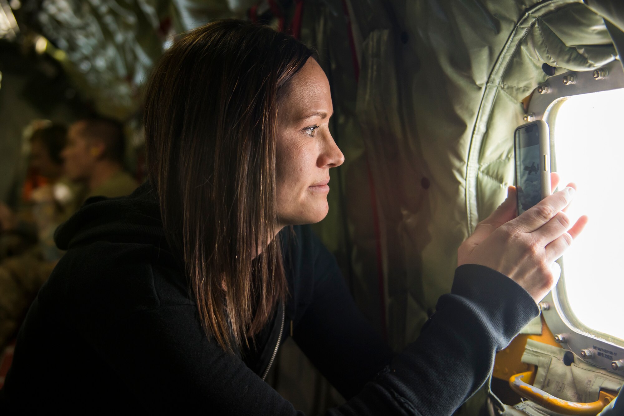 The wife of an Airman from the 124th Fighter Wing films an A-10 Thunderbolt || assigned to the 190th Fighter Squadron over Southwest Idaho, Dec. 7, 2019. The Idaho and Utah Air National Guard units collaborated to support an in-flight refueling experience for the spouses. (U.S. Air National Guard photo by Airman 1st Class Taylor Walker)