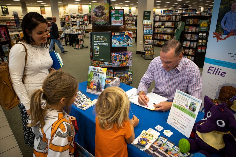Marine Maj. Joseph Goodrich signs a children’s book for a family at a book store in Jacksonville, North Carolina, Nov. 30, 2019. Goodrich, now a published author, read his book to fans and signed copies of his book for young readers. Goodrich is the executive officer of Marine Aerial Refueler Transport Squadron 252. (U.S. Marine Corps photo by Cpl. Cody Rowe)