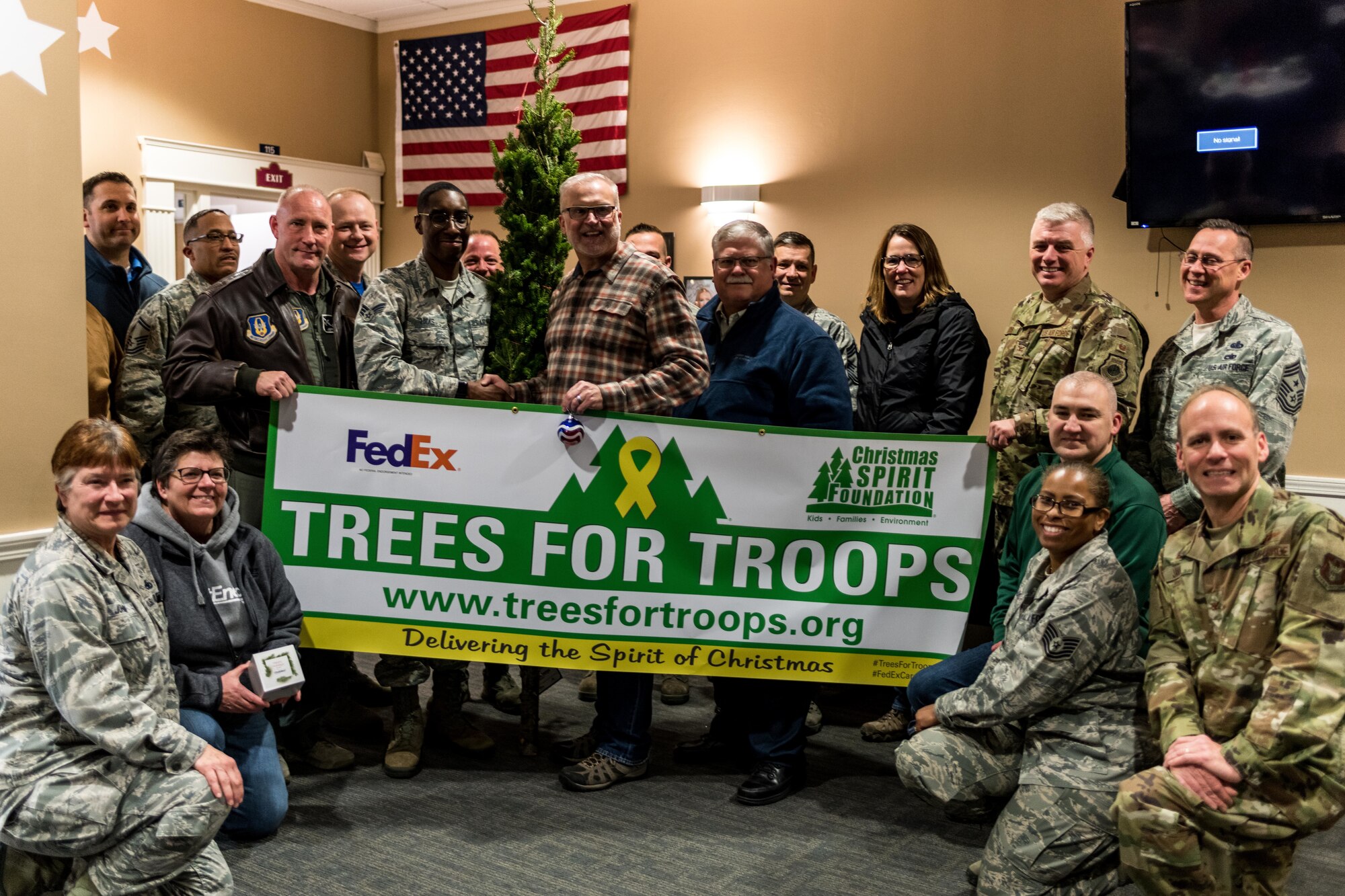 Senior Airman Lamont Hicks, 910th Airlift Wing commander’s support staff, stands with a group of 910th AW personnel and others after receiving the honorary "First Tree of Christmas" in a ceremony held in the USO of Northern Ohio’s on-base lounge here, Dec. 6, 2019.