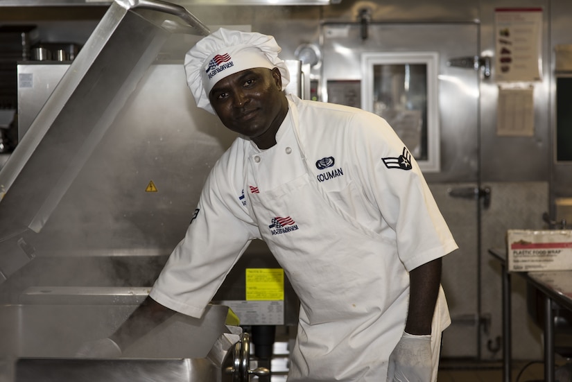 Airman 1st Class Kouassi Kouman, 87th Force Support Squadron food service apprentice, poses for a photo at the Halvorsen Hall Dining Facility Oct. 21, 2019 on Joint Base McGuire-Dix-Lakehurst, New Jersey. Kouman, who was born in Bondoukou, Africa, moved to the United States in 2014 after civil war threated his life while living in Africa. Kouman joined the Air Force in 2017.