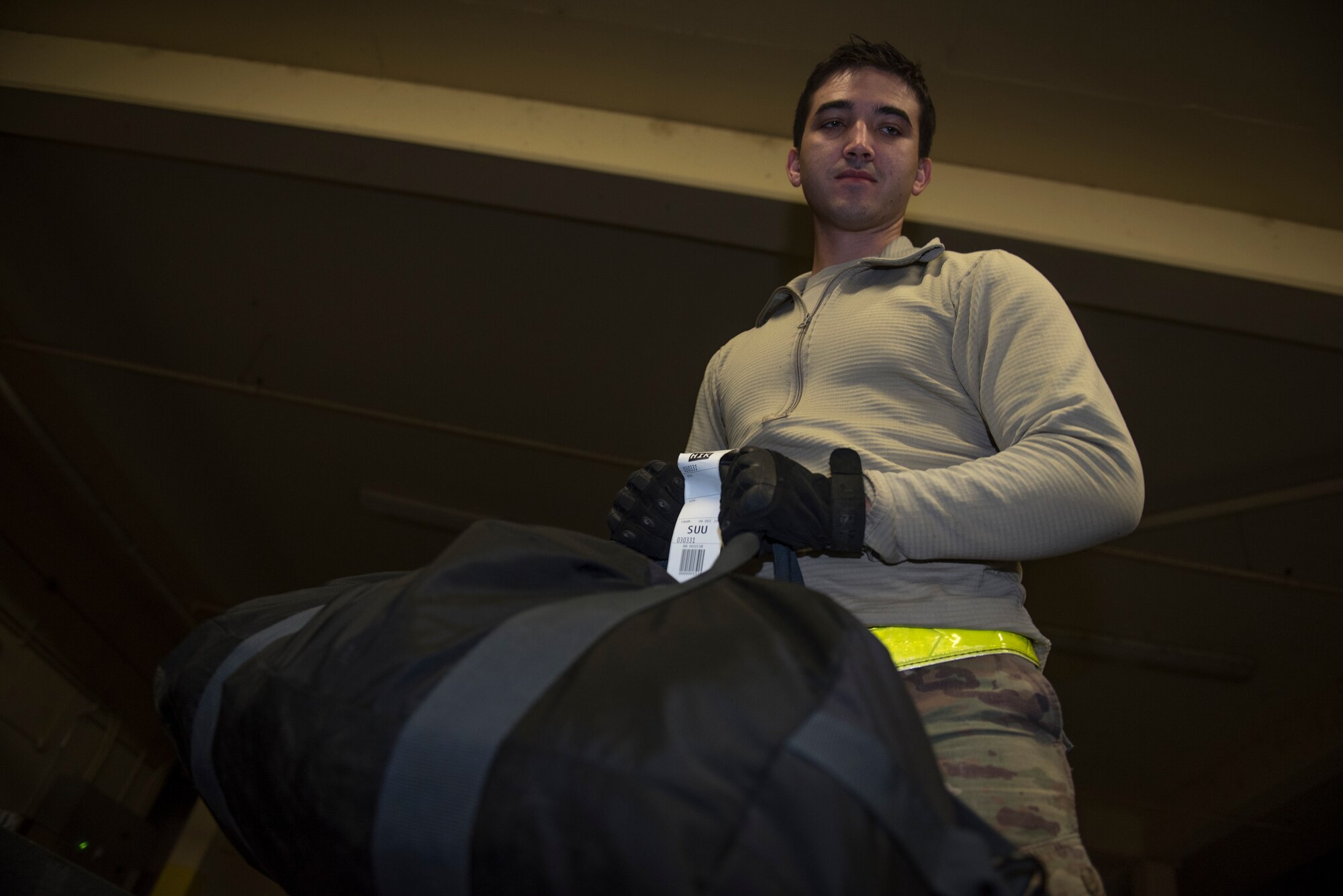 U.S. Air Force Senior Airman Cody Alderson, 60th Aerial Port Squadron air transportation agent, moves passengers’ luggage onto a pallet Dec. 6, 2019, at Travis Air Force Base, California. Alderson packed luggage onto a pallet so it could be loaded on an aircraft before departing Travis. (U.S. Air Force photo by Airman 1st Class Cameron Otte)