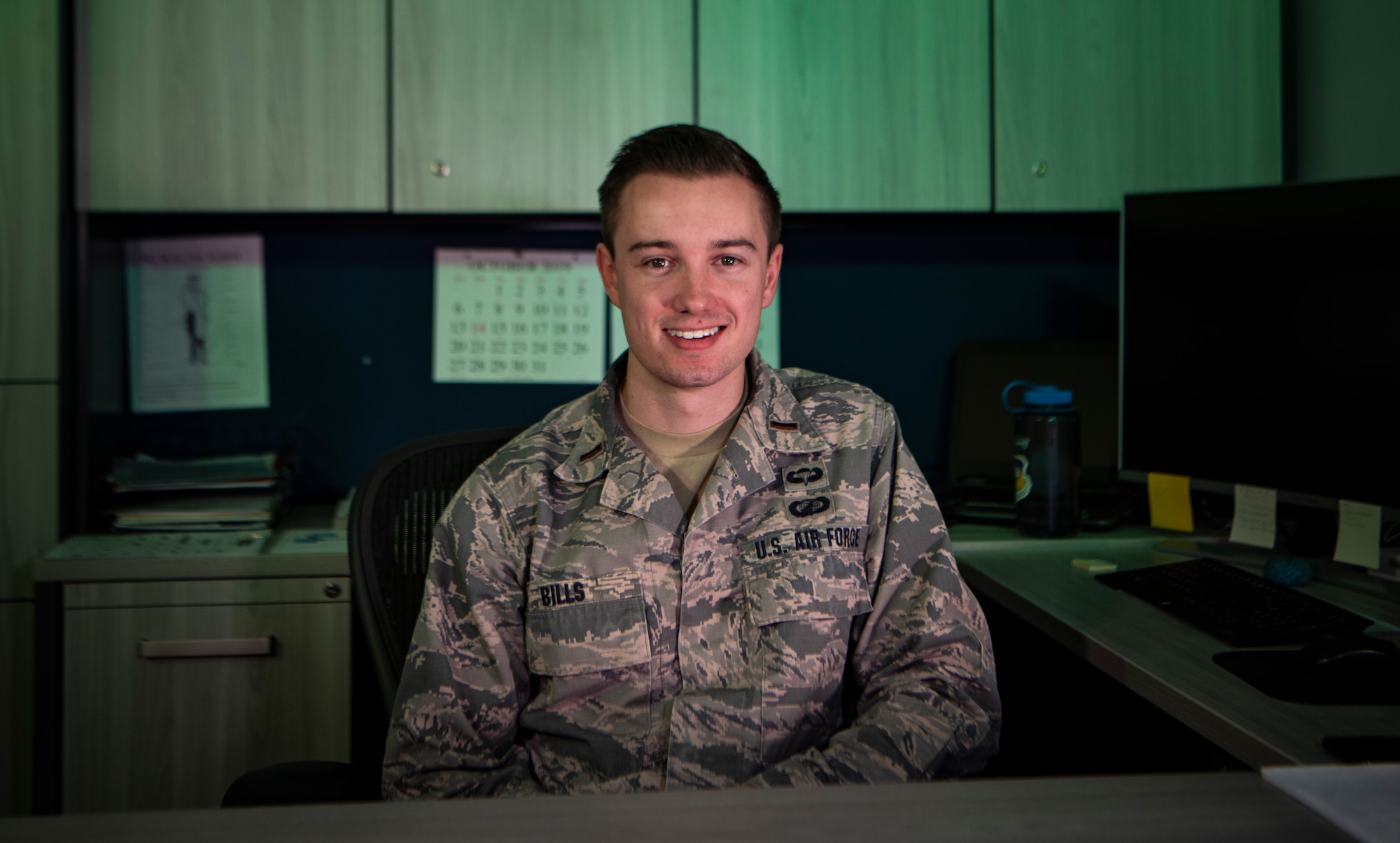 Airman sits at his desk.