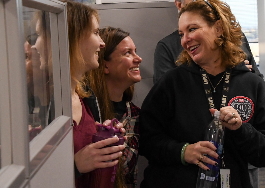 three women talking and laughing in an office