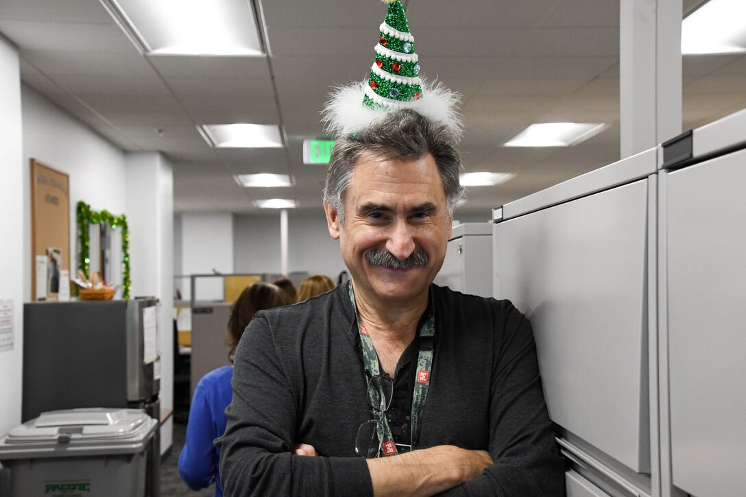 man in cone-shaped hat leaning against a file cabinet