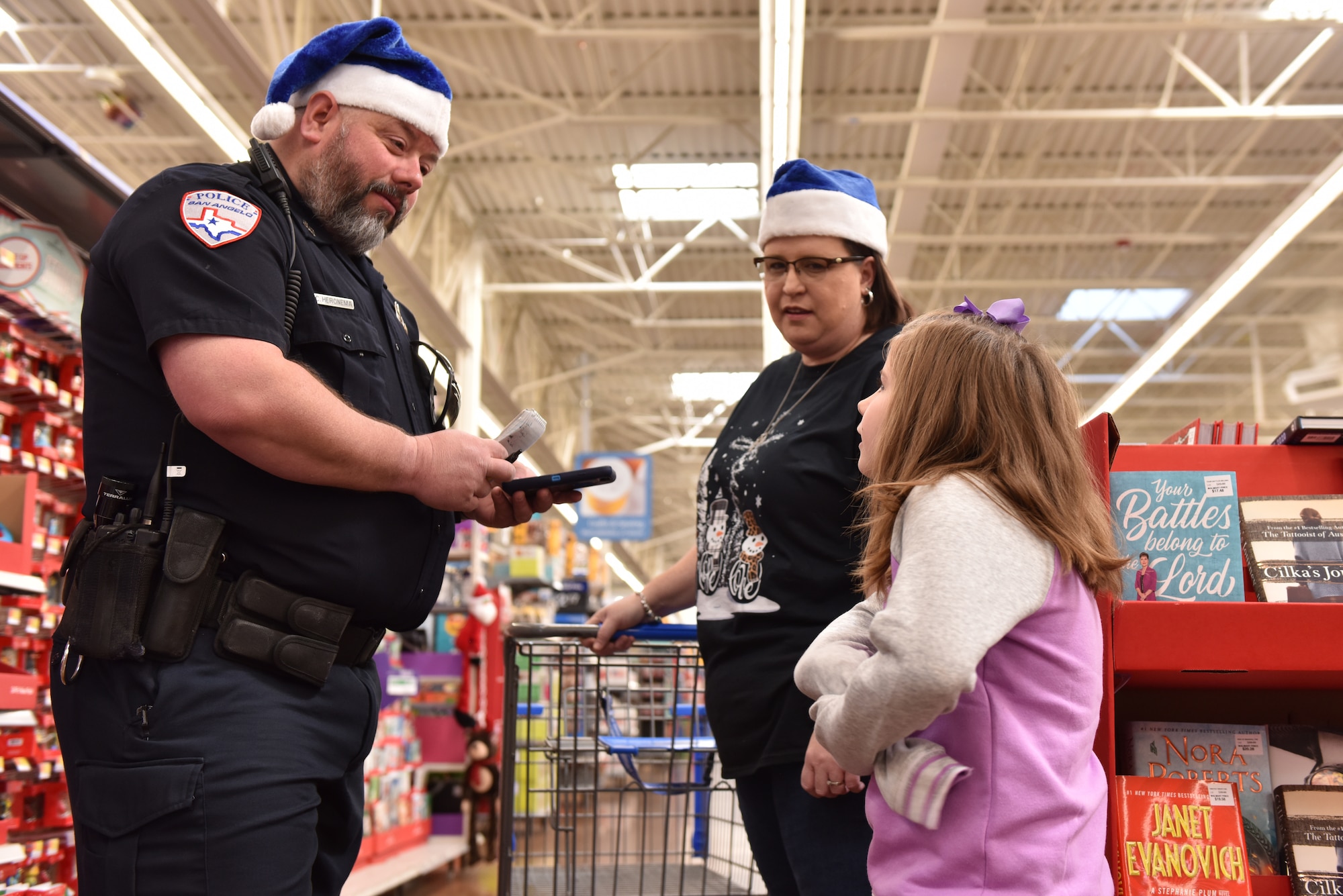 A San Angelo police officer talks with a child about their shopping list during the Operation Blue Santa Shop with a Cop event in San Angelo, Texas, Dec. 14, 2019. The children were able to pick out gifts for various family members and also themselves. (U.S. Air Force photo by Senior Airman Seraiah Wolf)