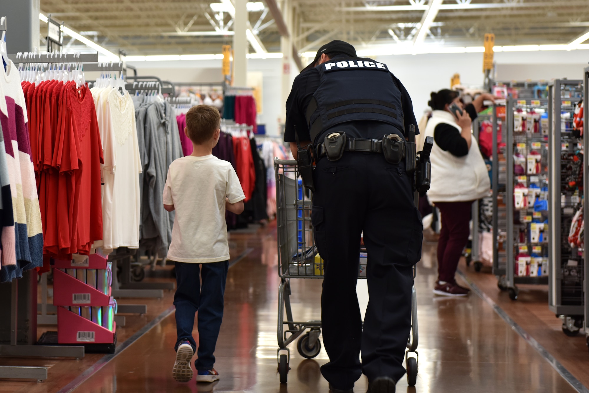 A child and his San Angelo police officer shopping partner walk while discussing what else they need to buy during the Operation Blue Santa Shop with a Cop event in San Angelo, Texas, Dec. 14, 2019. Each child who signed up for the event shopped with a police officer to purchase gifts for their family. (U.S. Air Force photo by Senior Airman Seraiah Wolf)