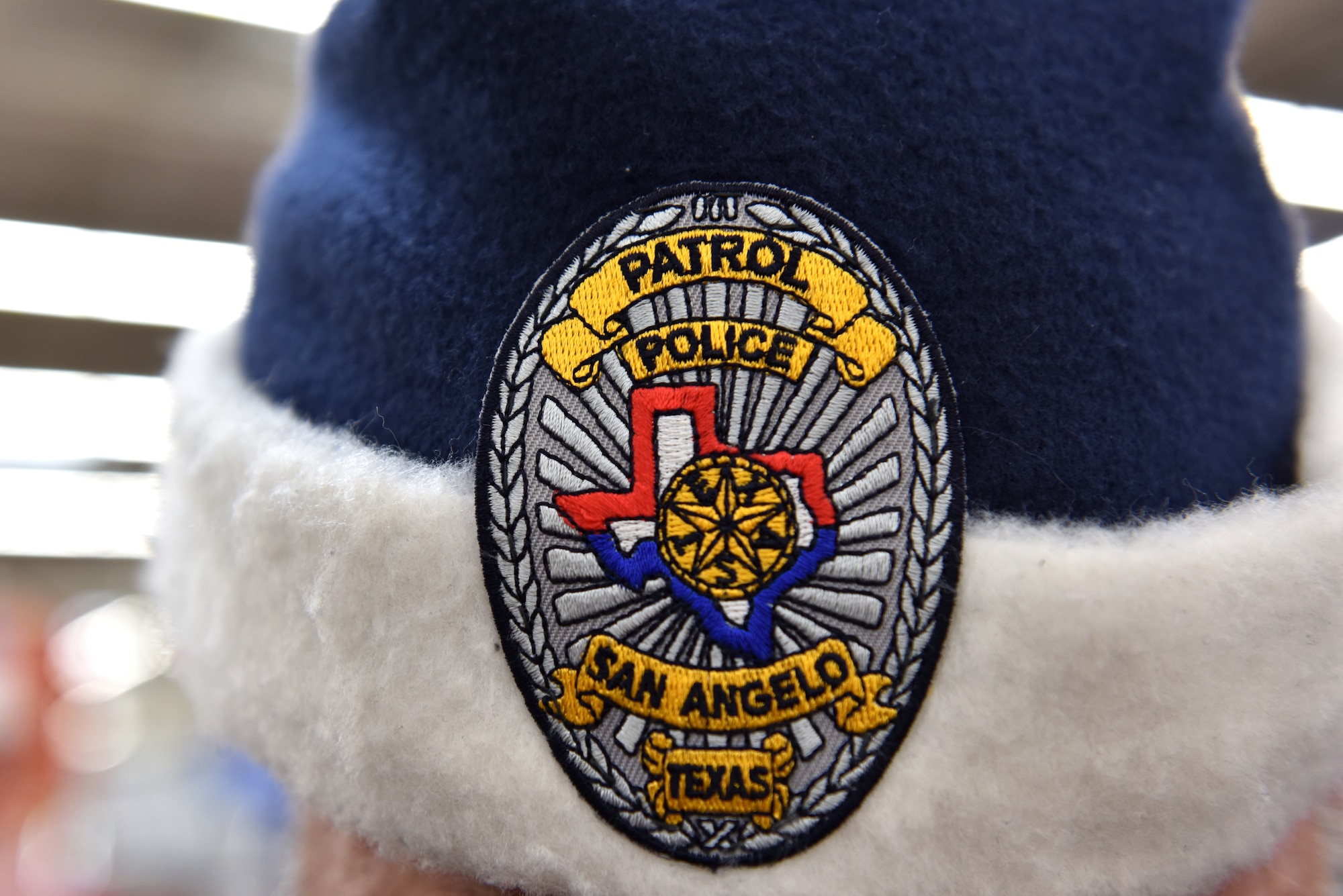 A police officer participating in Operation Blue Santa Shop with a Cop shows off his blue santa hat complete with a police badge in San Angelo, Texas, Dec. 14, 2019. This year there were multiple groups of children who shopped for their families with the police officers. (U.S. Air Force photo by Senior Airman Seraiah Wolf)