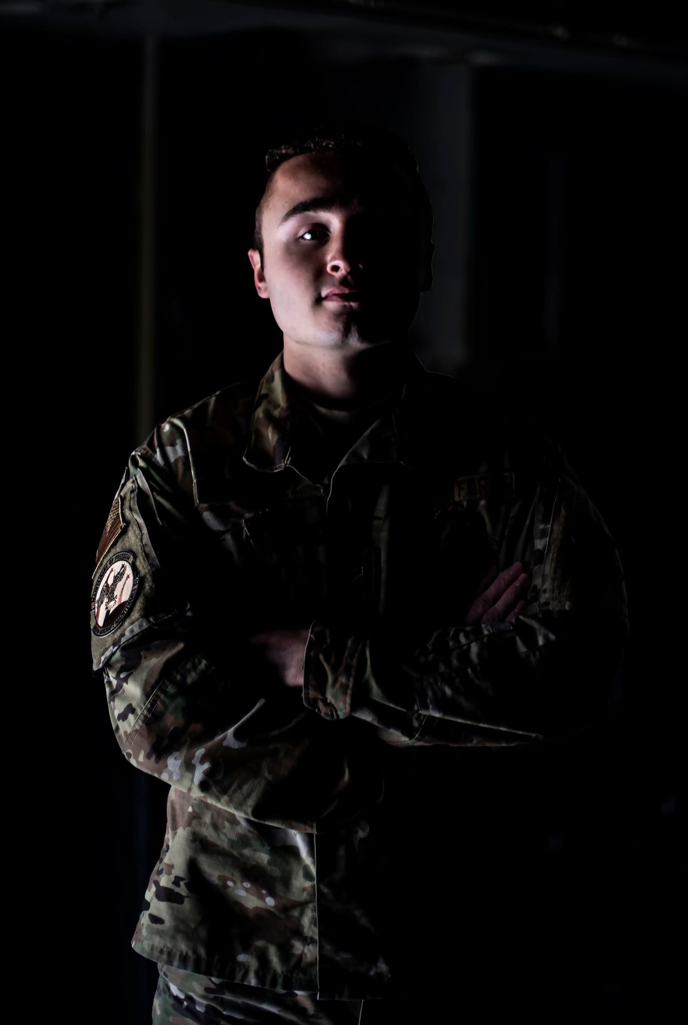 A man stands in the dimly-lit cargo bay of an aircraft.