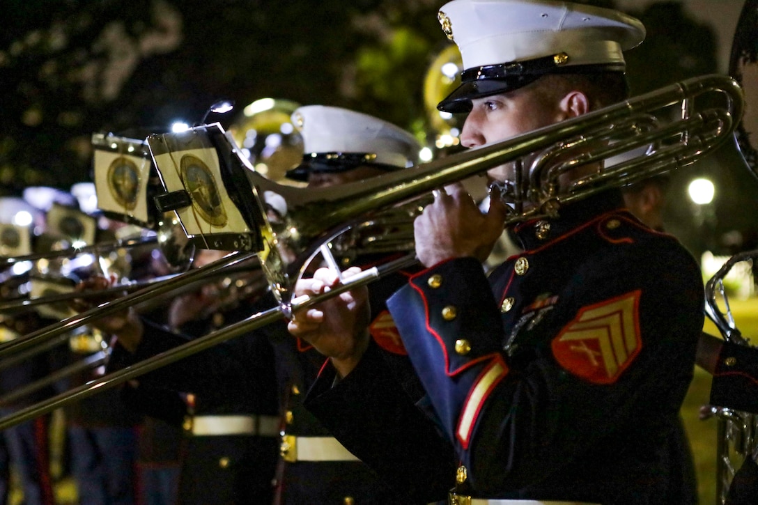 A Marine plays the trombone with the band.