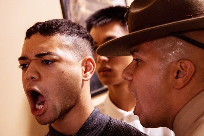 Staff Sgt. Felix Gomez, a drill instructor with Receiving Company, Support Battalion, corrects a recruit with Echo Company, 2nd Recruit Training Battalion, during receiving at Marine Corps Recruit Depot, San Diego, Dec. 9, 2019.