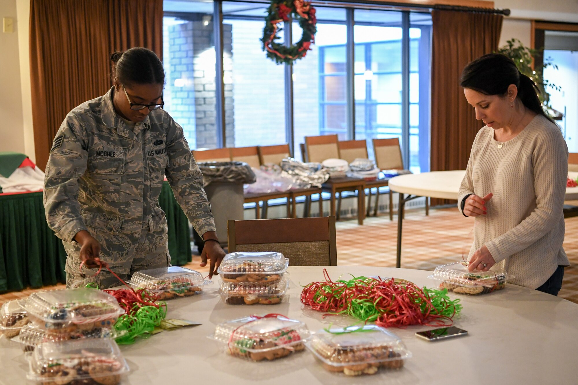Staff Sgt. Roshonda McGhee, 729th Air Control Squadron, and volunteer Alicia Walker wrap holiday cookie packages Dec. 16, 2019, at Hill Air Force Base, Utah, during the annual Team Hill Airmen Cookie Drive. Every year, volunteers bake, collect, package and deliver cookies to Hill AFB Airmen. (U.S. Air Force photo by Cynthia Griggs)