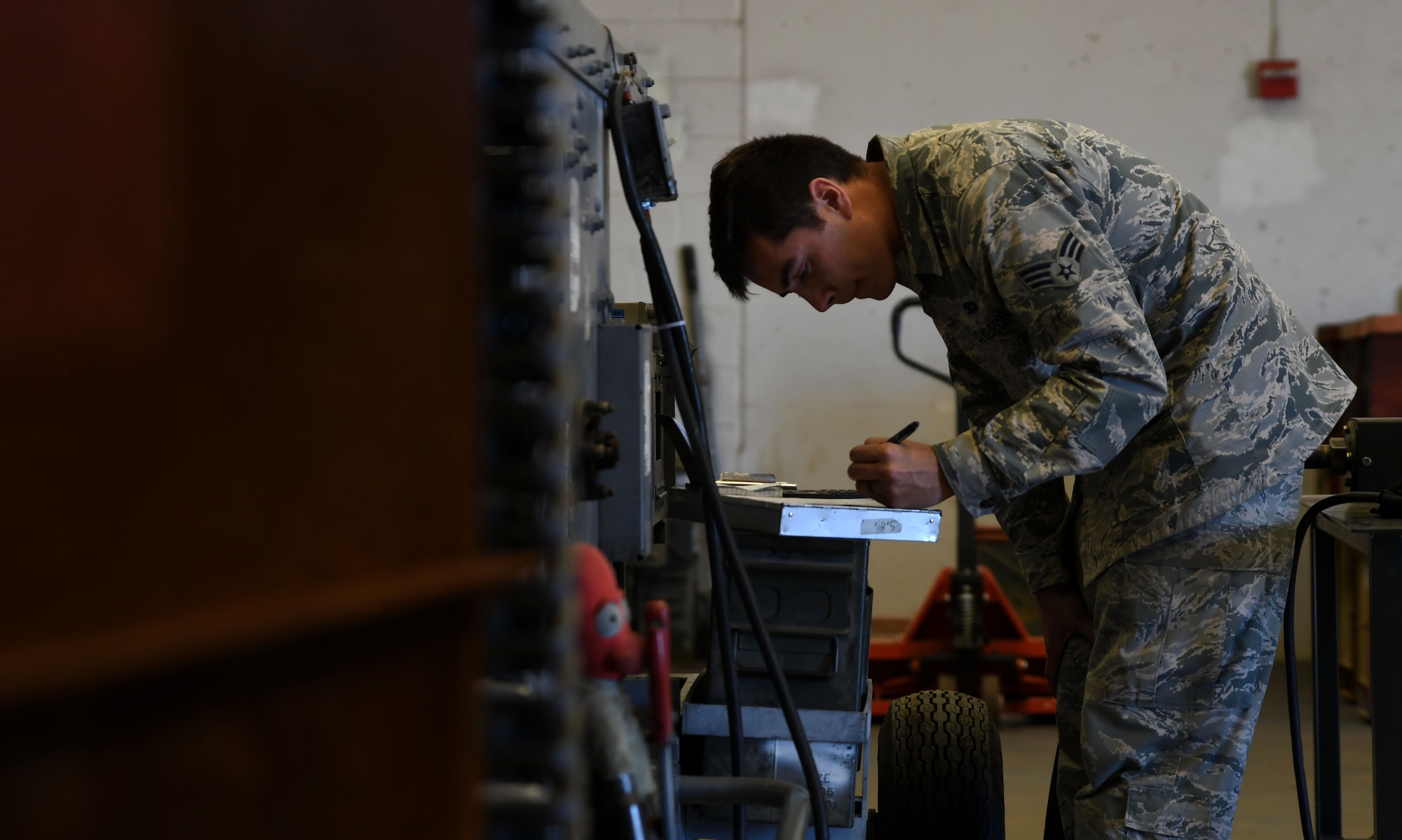 Photo of crew chief recording expended rounds process through a GFU-7/E “Dragon” processor