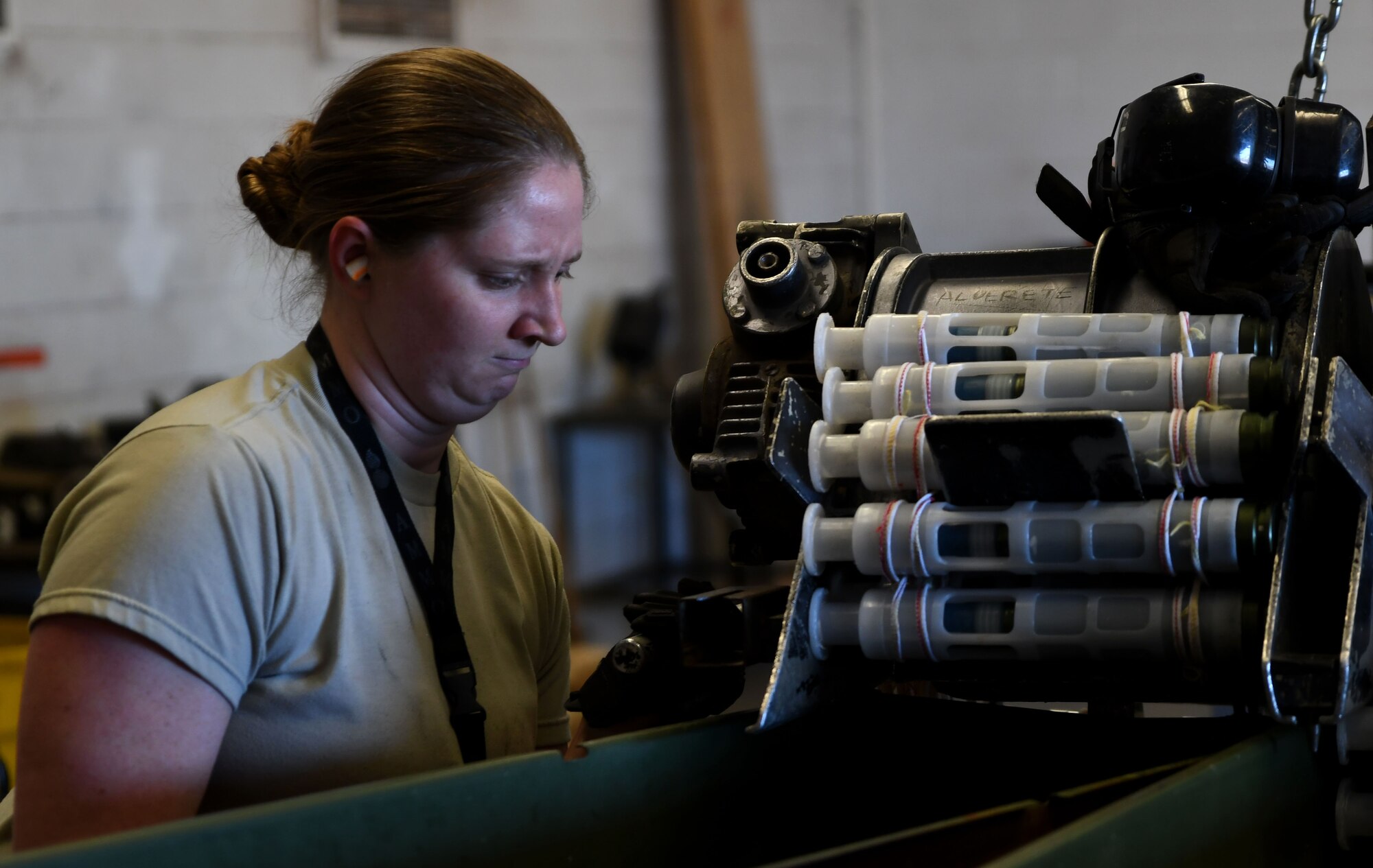 Photo of conventional munitions supervisor attaching a GFU-7/E “Dragon” processor to a munitions can