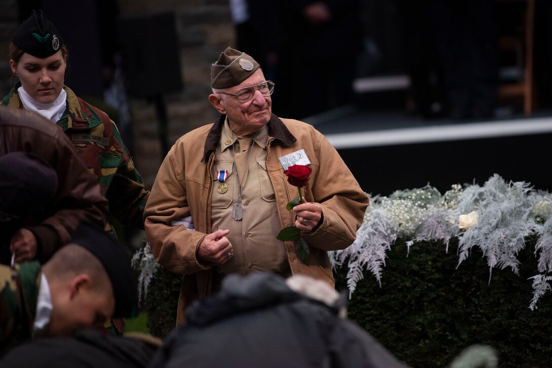 A veteran stands above a crowd of people at a ceremony.