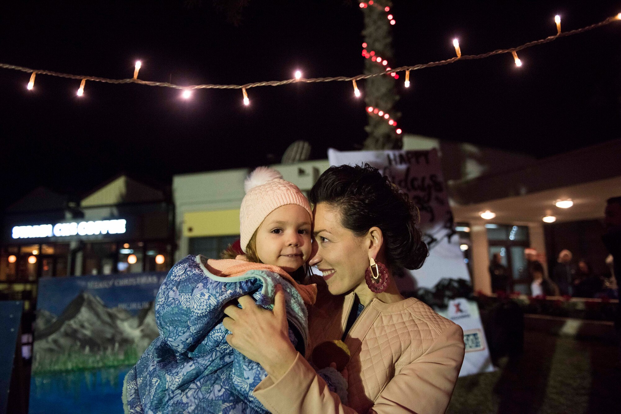 U.S. Air Force Maj. Crystal Karahan, 39th Air Base Wing executive officer, holds her daughter after the base Christmas tree lighting ceremony Dec. 5, 2019, at Incirlik Air Base, Turkey. U.S., Turkish and Spanish members of the community attended the ceremony. (U.S. Air Force photo by Staff Sgt. Joshua Magbanua)