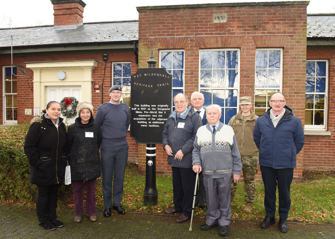 Members of The Heligoland 39 Project pose for a photo with Natalie Murphy, left, 100th Air Refueling Wing community relations advisor; Sqdn Ldr Paul Graham, third left, RAF Commander RAF Mildenhall; and Senior Airman Ashley Sperling, 100th ARW commander’s support staff, in front of the library at RAF Mildenhall, England, Dec. 16, 2019. The library built in 1931, was formerly the Sergeants’ Mess and family members (along with other guests) of the aircrew who led the daylight bombing raid on German ships Dec. 18, 1939, visited the base to see where their relatives lived and worked their time in the Royal Air Force 80 years ago. (U.S. Air Force photo by Karen Abeyasekere)